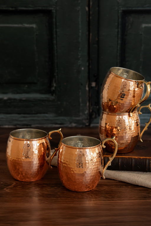Coppermill Kitchen | Vintage Inspired Moscow Mule Mugs, hammered-copper set of four with artisanal handles, ideal for enhancing your home bar's elegance and functionality.