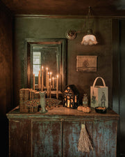 Coral & Tusk | Bat Surprise Doll with butterfly wings open, displayed on a moody Halloween-style sideboard with candles, lantern, and decorative items.