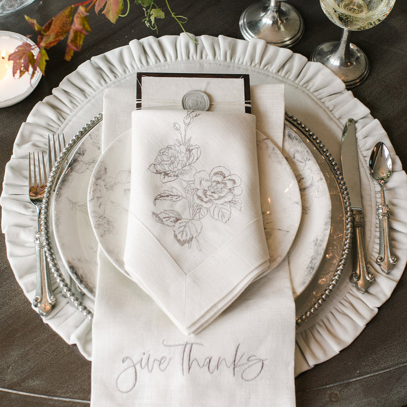 Round Ruffle Placemat 16.5 Inches with a beaded-rim charger, porcelain plate, embroidered napkin, and “give thanks” linen on an elegant tabletop setting.