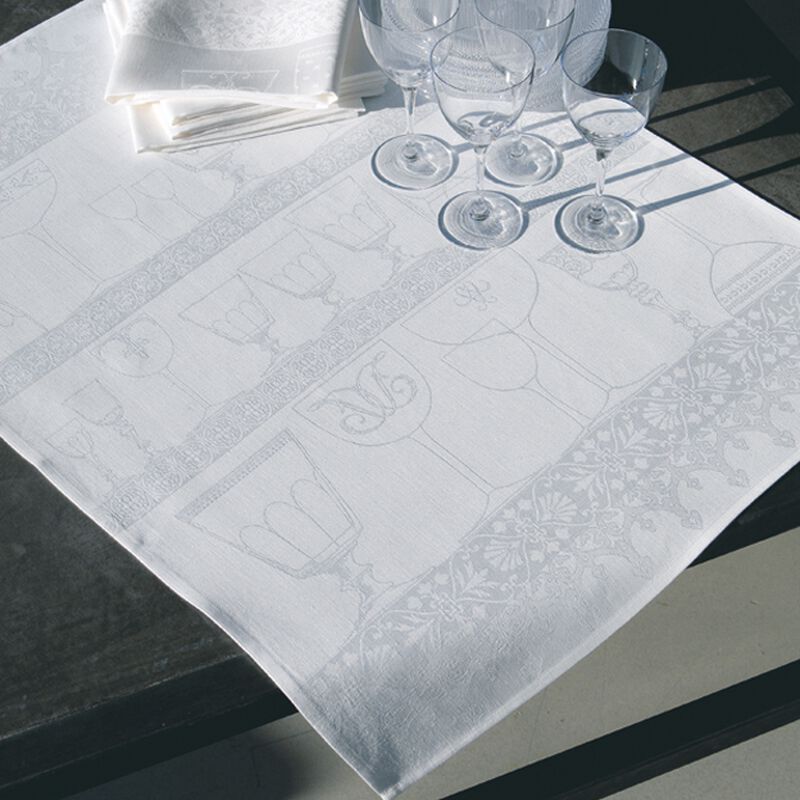 Le Jacquard Francais | Linen Crystal Towel, White, elegantly displayed on a dark wood table with matching napkins and stemmed wine glasses, showcasing its refined goblet motif.