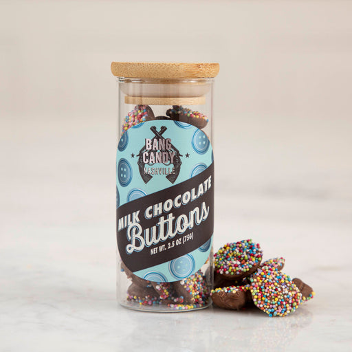 Hester & Cook | Buttons - Milk Chocolate in a clear jar with bamboo lid, featuring colorful nonpareil sprinkles for a delightful treat, perfect for gifts or snacking.