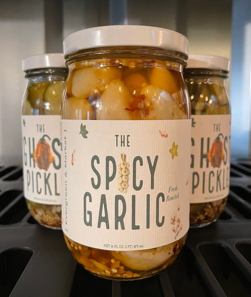 The Spicy Garlic by Evergreen and Market: Three jars of pickled garlic with spices, showcasing culinary excellence for enhancing dishes.