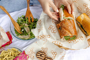 Bee's Wrap - Lunch 3 Pack - Honeycomb Print, featuring a sandwich wrap held by a person, ideal for sustainable, reusable food storage solutions.
