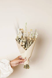 Idlewild Floral Co. - Sage Small Field Bouquet held in hand, featuring dried flowers wrapped in tan paper, perfect for adding a natural touch to any space.