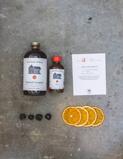 Pink House Alchemy - Toasted Caramel Syrup and cocktail ingredients for a Classic Old Fashioned, featuring syrup, recipe card, cherries, and dehydrated orange wheels.