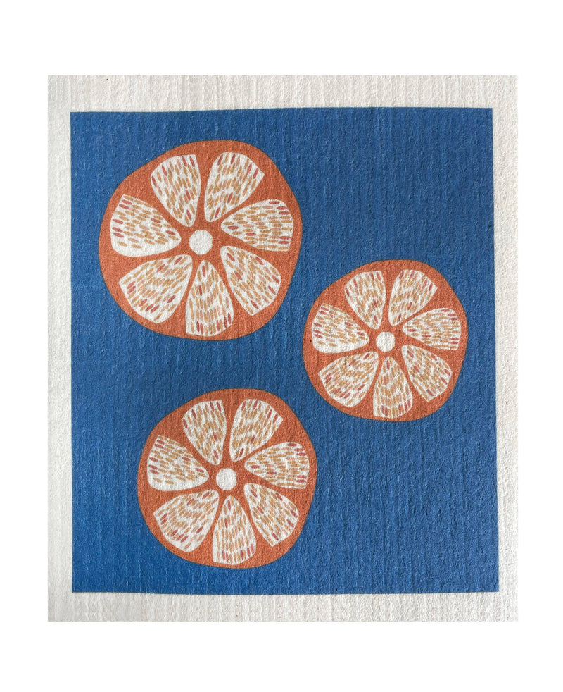 Ink and Fiber Designs - Oranges Swedish Dishcloth featuring blue and white patterns with orange motifs, ideal for eco-friendly cleaning, absorbing spills efficiently.