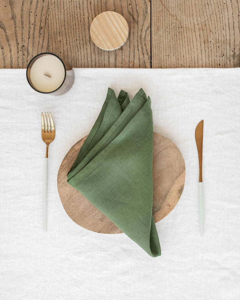 MagicLinen set of 2 linen napkins displayed on a wooden plate, featuring a candle holder, showcasing elegant table decor essentials.