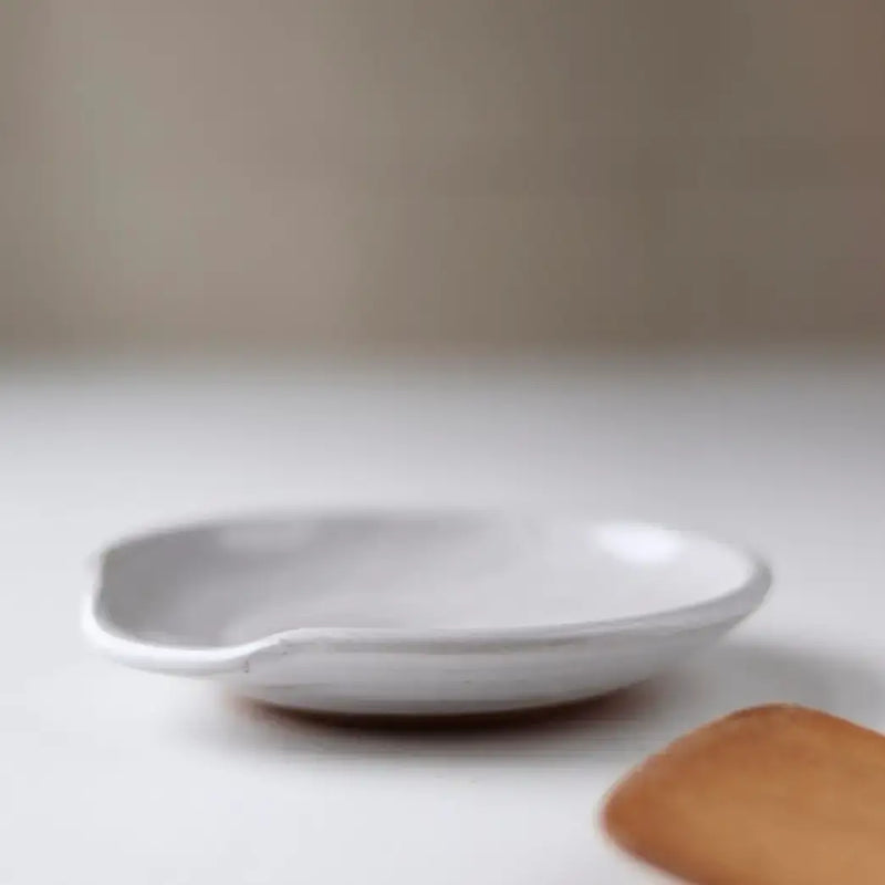 Gravesco Pottery - Handmade Pottery Spoon Rest on a white surface, accompanied by a small wooden spoon, highlighting its artisanal, functional design.