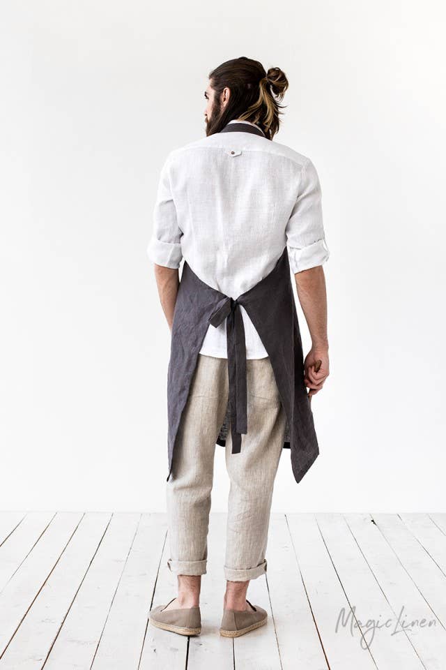 Man wearing MagicLinen men's linen apron with pocket, shown from waist up, demonstrating its adjustable straps and roomy front pocket, ideal for cooking or grilling.