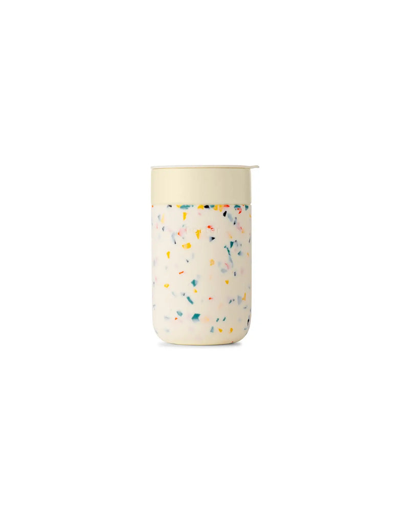 Reusable Ceramic Mug: Terrazzo Blush, 16 oz, with colorful sprinkles, BPA-free lid, and silicone sleeve. Ideal for eco-friendly coffee brewing.