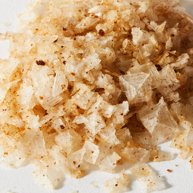 Jacobsen Salt Co. - White Truffle Salt features translucent flakes with reddish-brown seasoning, infused with Italian white truffle, ideal for enhancing various dishes.