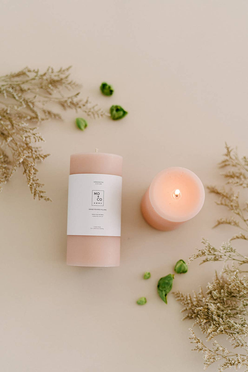 Mo&Co Home - 100% Beeswax Pillar Candles | Rose Pink: 3x4 Inch candle with a flame, accompanied by green leaves and a white paper with text.