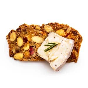Rustic Bakery - Artisan Crisps featuring tart cherries, cacao nibs, and almonds, topped with Brie and rosemary, showcasing a gourmet snack option from Athens Cooks.