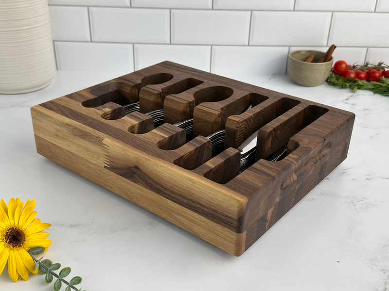 Loudblade - Custom Solid Walnut Wooden Flatware Drawer Organizer on countertop, holding stainless-steel cutlery, with ceramic bowl, herbs, and tomatoes nearby. Ideal for elegant kitchen storage.