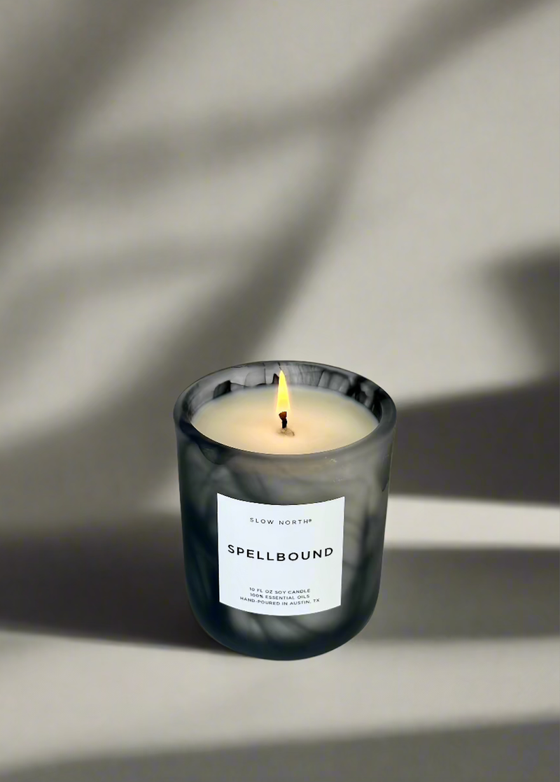 Slow North - Spellbound candle in marbled vessel, lit to reveal tangerine, ginger, and cinnamon scent. Hand-poured, limited edition for Halloween, 10 fl. oz., Austin, TX.