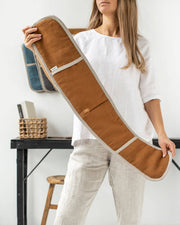 Woman holding MagicLinen double oven mitt, a natural linen kitchen accessory designed for heat protection, showcasing sustainability through zero-waste production.