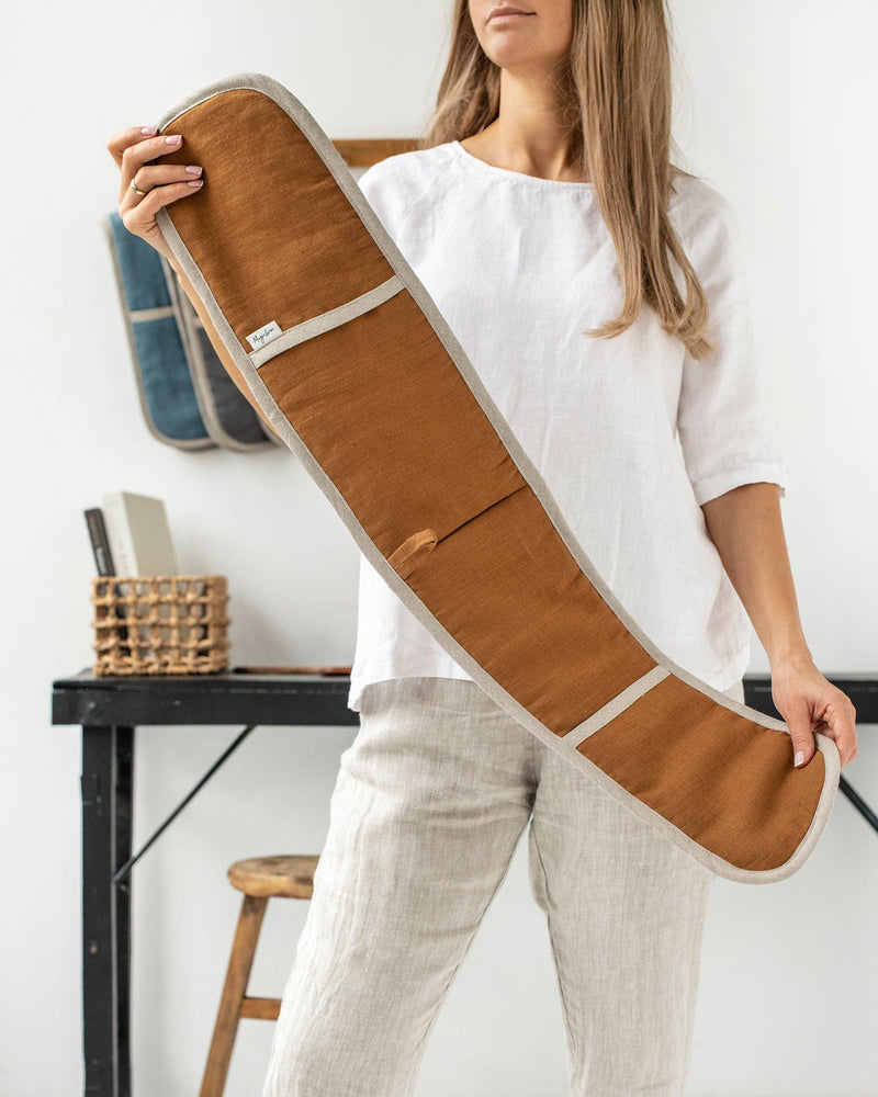 Woman holding MagicLinen double oven mitt, a natural linen kitchen accessory designed for heat protection, showcasing sustainability through zero-waste production.