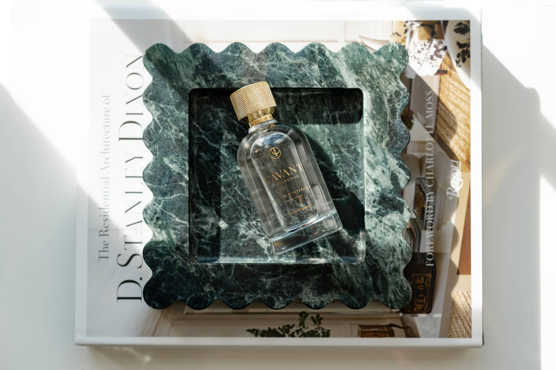 L'AVANT Collective - Blushed Bergamot Room Spray 100 ml in a clear bottle with gold cap, nestled in a green tray for elegant home fragrance.