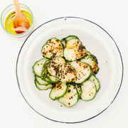 Villa Jerada - Urfa Biber - 50g pepper enhances cucumber dish with charred slices, chili flakes, herbs, and drizzled oil, embodying complex, mild, smoky flavors.