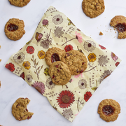 Bee's Wrap - Cut-to-Size Roll - Meadow Magic displayed with homemade cookies, showcasing its versatility and sustainability as a reusable, plant-based food wrap.