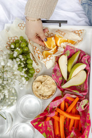 Bee's Wrap - Assorted 3 Pack - Splendid Spring showcasing reusable fabric wraps with fruits, vegetables, and a bowl of hummus, ideal for sustainable food storage.