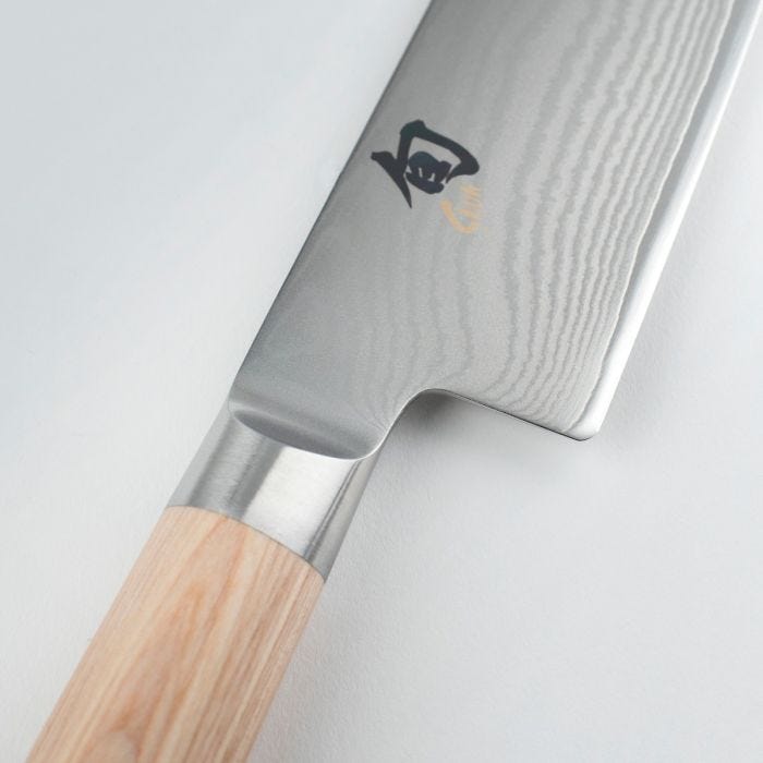 Shun | Classic Blonde Santoku, 7 features a Damascus-patterned steel blade and a light wooden handle, highlighting its precision craftsmanship and versatile kitchen use.
