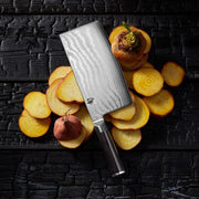 Shun | Classic Vegetable Cleaver, 7 inches, with Damascus steel blade and wooden handle, displayed with sliced golden beets on a dark wooden backdrop.