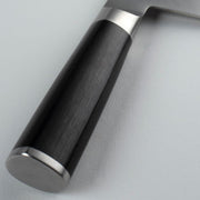 Shun Classic Vegetable Cleaver, 7 inches, features a close-up of its D-shaped Pakkawood handle with a metal bolster and end cap, ideal for versatile kitchen tasks.