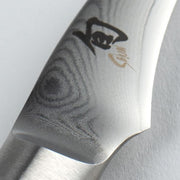 Close-up of Shun Classic Bird's Beak Paring knife, 2.5 inches, showcasing the Damascus steel pattern and bolster, ideal for decorative and precise culinary cuts.
