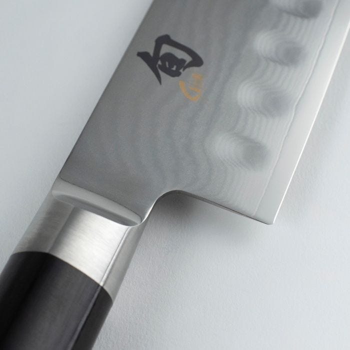Shun Classic Hollow Ground Santoku, 7 inches, featuring a hammered Damascus finish and octagonal Pakkawood handle, ideal for versatile kitchen use.