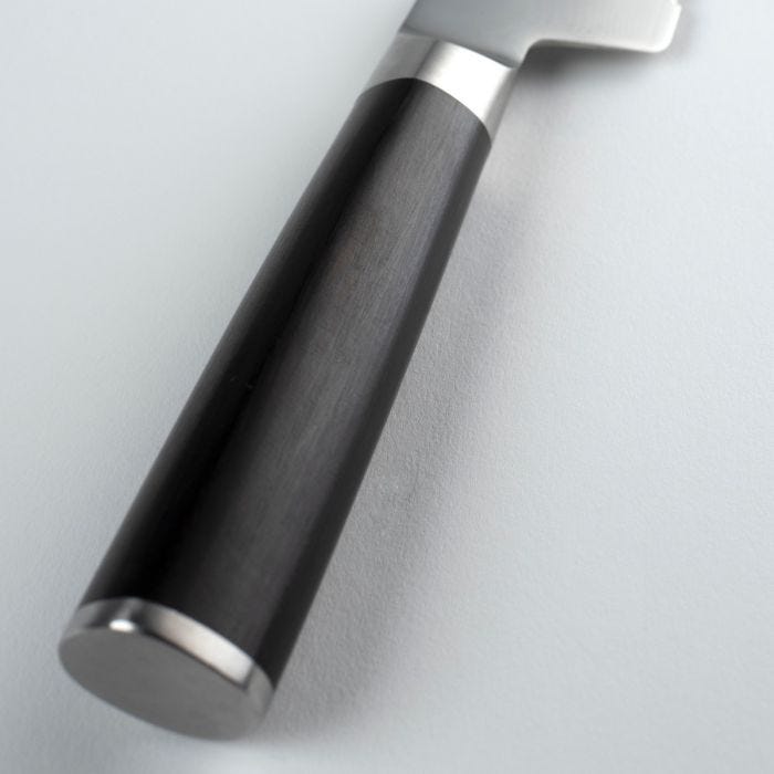 Close-up of Shun Classic Offset Bread Knife's black handle with metal accents, designed for enhanced knuckle clearance and ease in slicing crusty loaves.