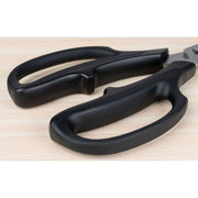 Shun Kitchen Herb Shears, 7.5 inches, with black handles on a wooden surface, featuring a fine 16° cutting edge and ergonomic grip for easy herb cutting.