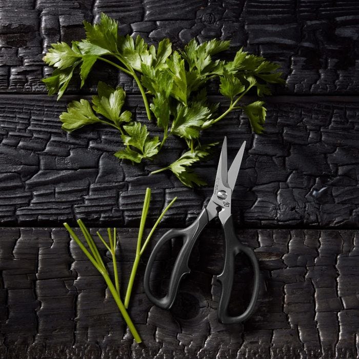 Shun | Kitchen Herb Shears, 7.5 inches, on wood, with freshly-cut parsley. Features ergonomic grip, stainless steel blades, and easy-clean separation for precise herb cutting.