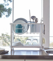 Yamazaki Home | Two-Tier Dish Rack - White, features a compact design with a versatile, adjustable plastic drainer tray and utensil holder for efficient kitchen space use.