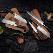 Shun Dual Core Santoku knife, 7 inches, with a black handle, displayed on wooden cutting boards amidst fresh produce and Himalayan salt, showcasing its versatile design.