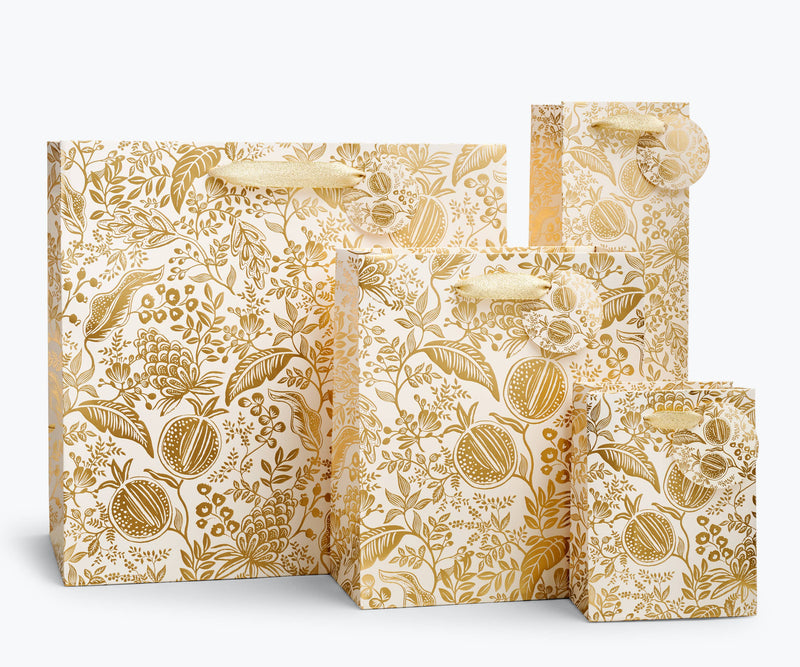 Rifle Paper Co. - Pomegranate Gift Bag set with gold botanical pattern, varied sizes, gold ribbon handles, and tags, ideal for elegant gift-giving from Athens Cooks.