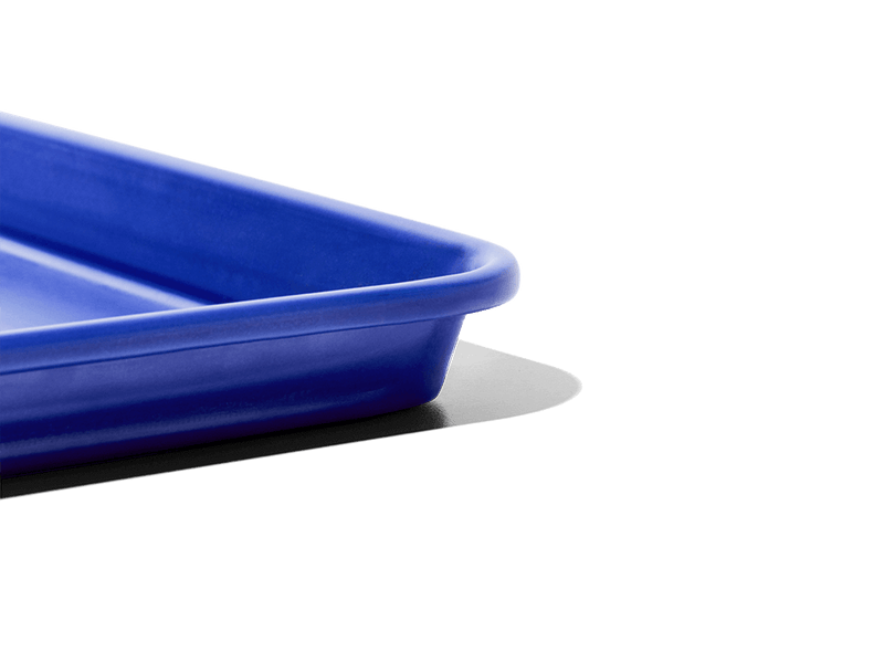 Great Jones | Little Sheet - Pepper, a small, nonstick sheet pan ideal for baking and reheating, showcased against a black backdrop, embodying Athens Cooks' curated kitchen essentials.