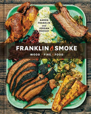 Cover of Franklin Smoke: Wood Fire Food by Aaron Franklin and Jordan Mackay, featuring a green platter of smoked meats and vegetables, emphasizing backyard grilling and smoking techniques.