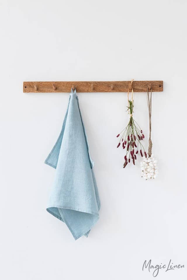 Linen tea towel hanging with flowers, showcasing its loop feature. Made from European flax, it’s perfect for kitchen use. Part of MagicLinen's collection at Athens Cooks.