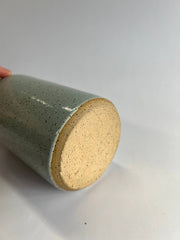 Hand holding RachaelPots - Oil Cruet Large: Nude/White, a handmade ceramic oil container with a pour spout, ideal for kitchen use.