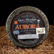 Nicola's Marketplace - DOP Aurora Manchego Kosher Cheese Wedge: 6 ounces, semi-soft sheep’s-milk cheese from Spain, aged 6 months, with visible certification and nutrition details.