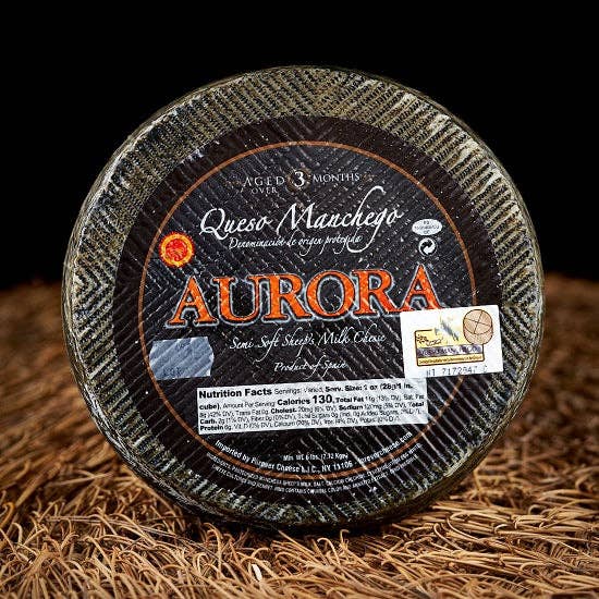 Nicola's Marketplace - DOP Aurora Manchego Kosher Cheese Wedge: 6 ounces, semi-soft sheep’s-milk cheese from Spain, aged 6 months, with visible certification and nutrition details.