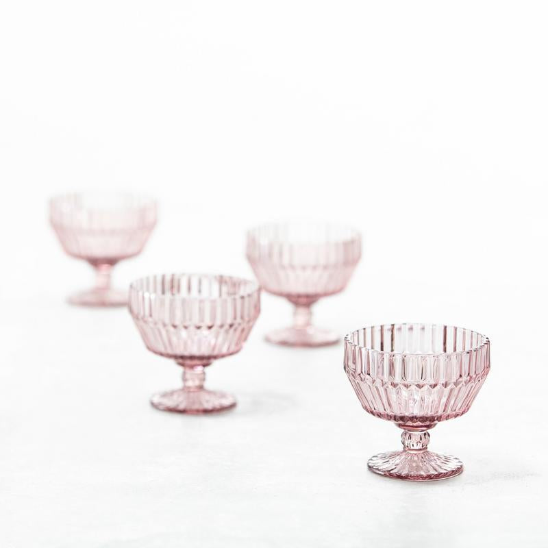 Fortessa | Archie Pink Coupe/Footed 10oz Dessert Bowl displayed in a still life setting, showcasing its elegant design and glass craftsmanship.