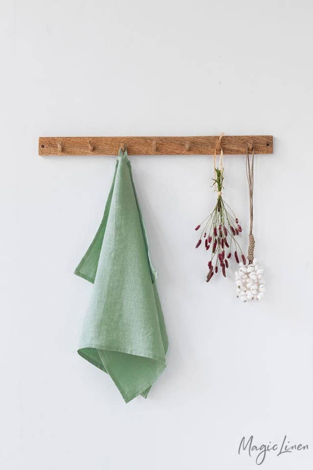 Linen tea towel hanging with flowers, showcasing MagicLinen's high-quality European fabric, perfect for kitchen use. Includes loop for easy hanging.
