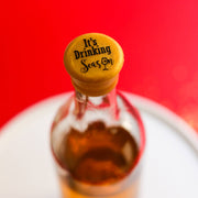 CapaBunga | Holiday Wine Caps - Shhh! I Need a Silent Night: Close-up of a glass bottle with a yellow cap, designed for festive wine preservation.