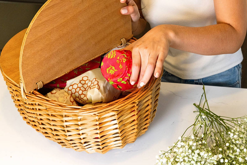 Bee's Wrap - Assorted 3 Pack - Splendid Spring held in a basket, showcasing reusable fabric food storage wraps with vibrant spring designs.