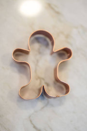 Galley and Fen - Christmas Cookie Cutters - Set of 6, featuring a copper gingerbread-man cutter on a countertop, ideal for festive baking with clean cuts.