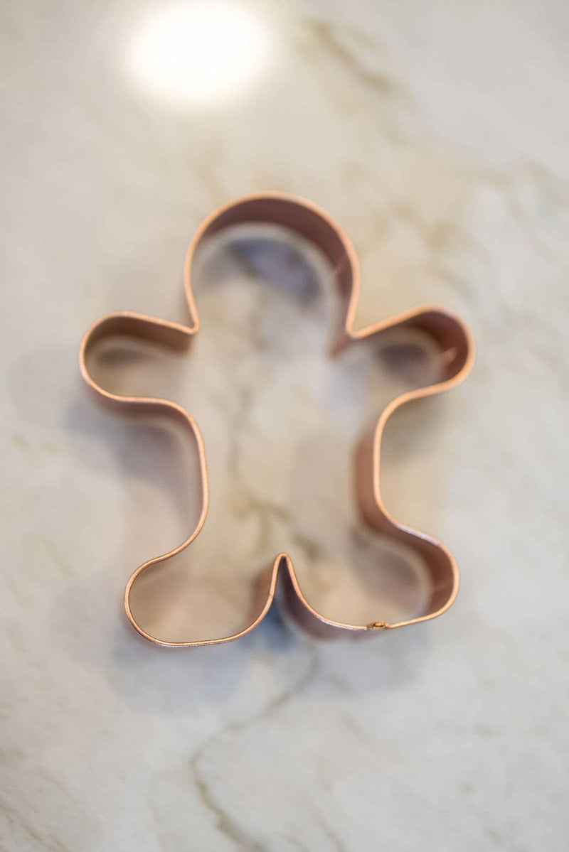 Galley and Fen - Christmas Cookie Cutters - Set of 6, featuring a copper gingerbread-man cutter on a countertop, ideal for festive baking with clean cuts.
