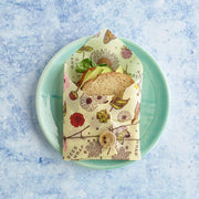 Bee's Wrap - Sandwich Wrap - Meadow Magic, Vegan Wax secures a veggie sandwich, showcasing a reusable wrap with a wooden button and twine on a kitchen plate.