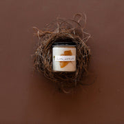 Among the Flowers - Essential oil candle | HOLIDAY: Hearth nestled in a bird-nest bowl, featuring ivory soy wax with amber decor.